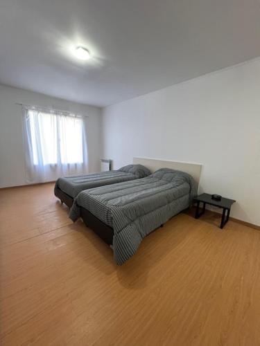 a bedroom with a bed in a room with a wooden floor at Dúplex del Pinar-Plottier-Diario Semanal Mensual-La Mejor Ubicación-Estacionamiento Privado in Plottier