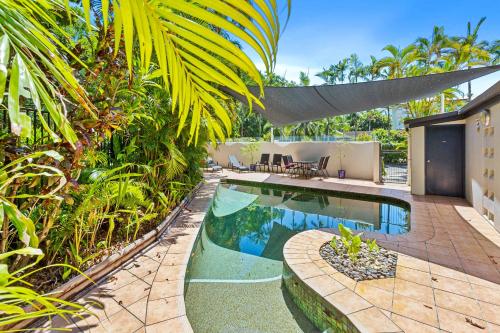 a backyard with a swimming pool and a house at Melaleuca Hideaway - Beach Pool free parking in Yorkeys Knob