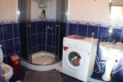 uma casa de banho com uma máquina de lavar roupa e um WC em Hostel Ilbirs em Karakol