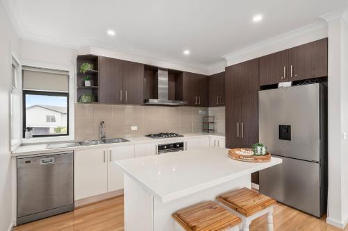Una cocina con encimera blanca y refrigerador. en Tides Edge, en Indented Head