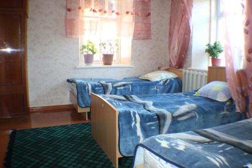 um quarto com quatro camas e uma janela em Hostel Ilbirs em Karakol