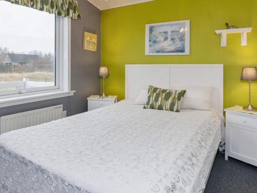 a bedroom with a white bed and a yellow wall at 8 person holiday home in Løgstør-By Traum in Trend