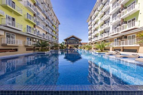 a large swimming pool in the middle of two buildings at 309B Condotel Near Airport &Mall,Pool,Gym,Netflix in Pusok