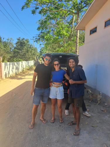 a group of three people standing in front of a car at Coco Colada Bungalows in Kuta Lombok