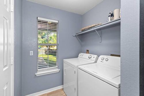 a laundry room with a washer and dryer and a window at Luxury farmhouse - 10 min from DT - sleeps 10 in Austin