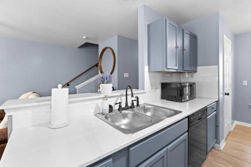 a kitchen with a sink and a microwave at Luxury farmhouse - 10 min from DT - sleeps 10 in Austin