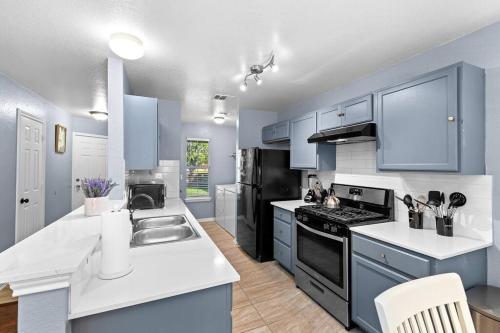 a kitchen with blue cabinets and white counter tops at Luxury farmhouse - 10 min from DT - sleeps 10 in Austin