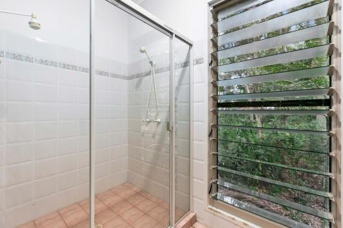 a shower with a glass door in a bathroom at Sandy Paws in Toogoom in Toogoom