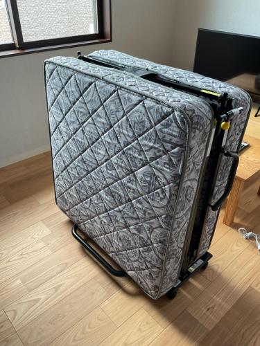 an open suitcase sitting on the floor in a room at かなわアパートメントステイ201 in Tsuruga