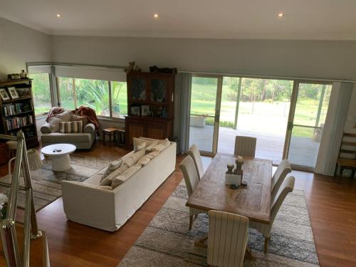 a living room with a couch and a table at Grandma's Farm Cottage in Woodhill