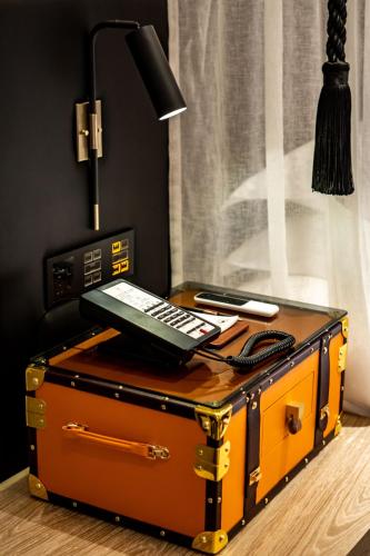 a desk with a lamp on top of a suitcase at Arthur Hotel Zhujiang New Town Guangzhou-Free Shuttle Bus to Exhibition Centre during Canton Fair in Guangzhou