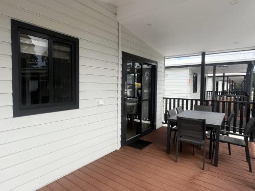 a porch with a table and chairs on a deck at Discovery Parks - Eden in Eden