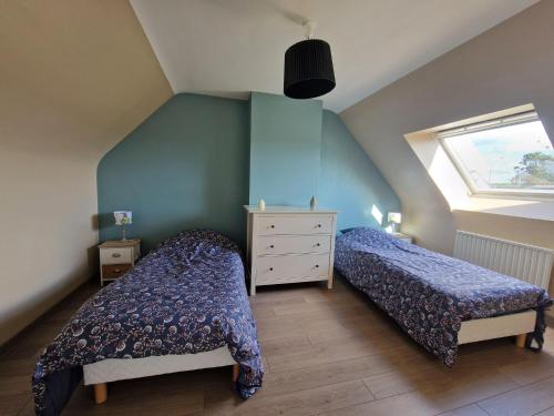 a attic bedroom with two beds and a window at Holiday Home in Paimpol near Beach in Paimpol