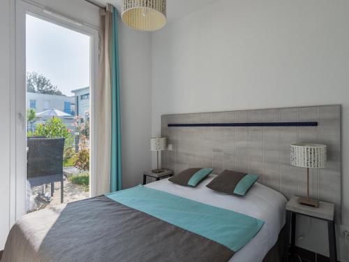 une chambre avec un grand lit et une grande fenêtre dans l'établissement Apartment in France near the Coastline, à Saint-Palais-sur-Mer