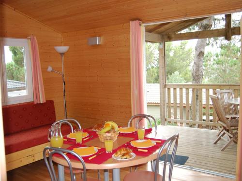 une salle à manger avec une table et des chaises sur un porche dans l'établissement Cottage in France with Airy Terrace, à Agde