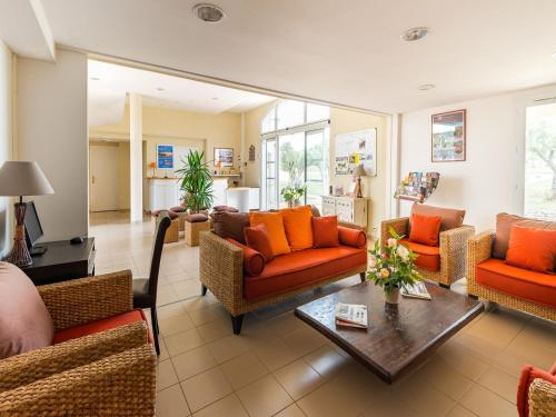 - un salon avec des canapés orange et une table dans l'établissement Apartment in Provence near Alpilles, à Paradou