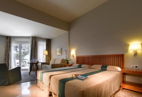 Un dormitorio con una cama grande y una sala de estar. en Parador de Cordoba, en Córdoba