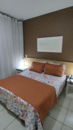 ein Schlafzimmer mit einem Bett und zwei Kissen darauf in der Unterkunft Flat Village - Aldeia das águas in Sapucaia