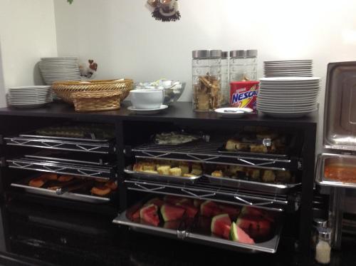 a shelf filled with food and plates on a counter at Hotel America do Sul in Sao Paulo
