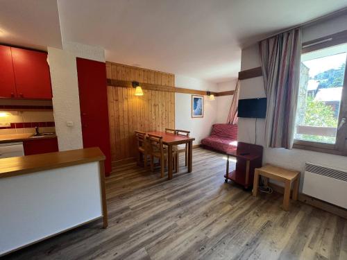 Cette chambre comprend une cuisine et une salle à manger avec une table. dans l'établissement Appartement calme avec piscine, parking, animaux acceptés - La Plagne 1800 - FR-1-351-220, à La Plagne Tarentaise