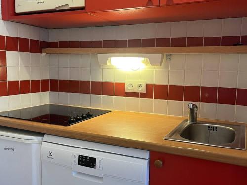 une cuisine avec un évier et un plan de travail dans l'établissement Appartement calme avec piscine, parking, animaux acceptés - La Plagne 1800 - FR-1-351-220, à La Plagne Tarentaise