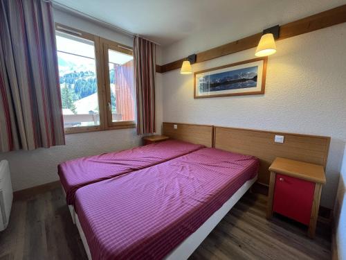 - une chambre avec un lit violet dans l'établissement Appartement calme avec piscine, parking, animaux acceptés - La Plagne 1800 - FR-1-351-220, à La Plagne Tarentaise