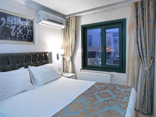 イスタンブールにあるMonarch Hotel Istanbulのベッドと窓が備わるホテルルーム
