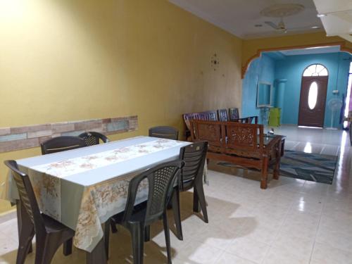 a dining room with a table and chairs at Husna Homestay Kota Harmoni Tanah Merah in Tanah Merah
