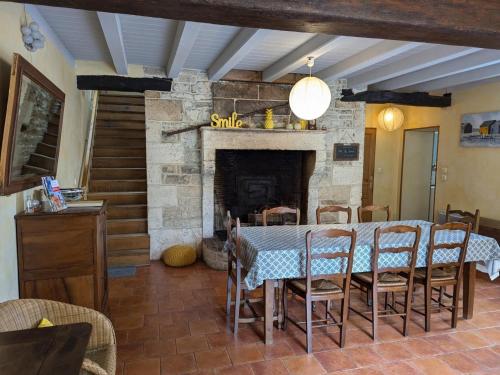 une salle à manger avec une table et une cheminée dans l'établissement Gîte cosy avec 3 chambres, cour privée, baby-foot et internet, équipements bébé inclus, animaux permis - FR-1-653-154, à Jauldes
