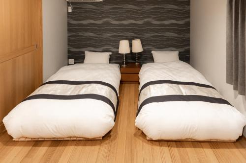 two beds sitting next to each other in a room at moku杢 つばき in Miyazu