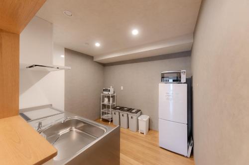 a kitchen with a sink and a refrigerator at moku杢 つばき in Miyazu