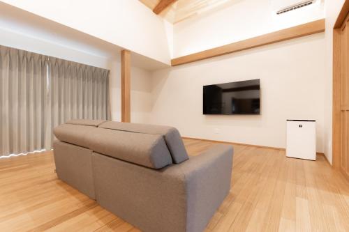 a living room with a couch and a flat screen tv at moku杢 つばき in Miyazu