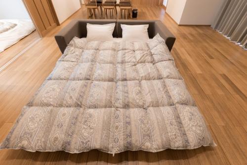 a large bed in a room with a wooden floor at moku杢 つばき in Miyazu