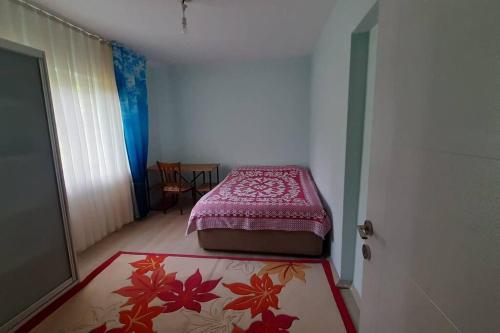 a small bedroom with a bed and a red blanket at Bahceli ev 