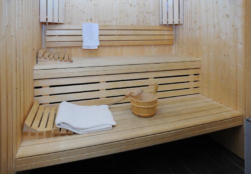 a wooden bench in a sauna with a bucket at Residhome Grenoble Caserne De Bonne in Grenoble