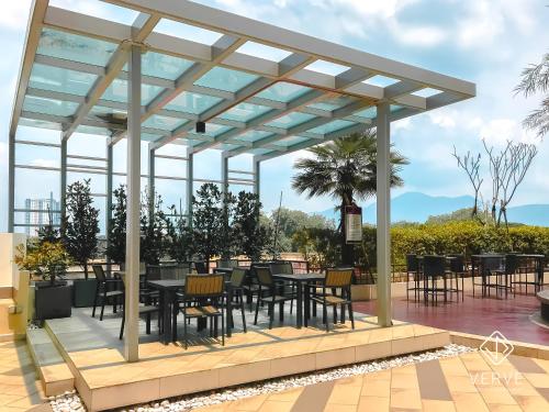 a pergola with tables and chairs on a patio at Ipoh Majestic Premium Suites by Verve in Ipoh