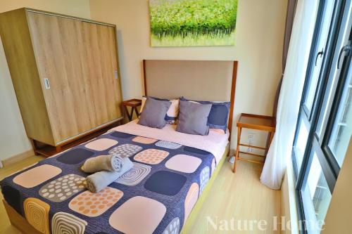 a bedroom with a bed with blue and pink at Timurbay Seafront Residences by Nature Home in Kuantan