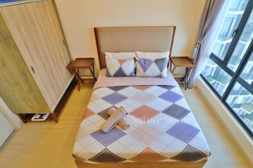 a bed with a cross on it in a room at Timurbay Seafront Residences by Nature Home in Kuantan