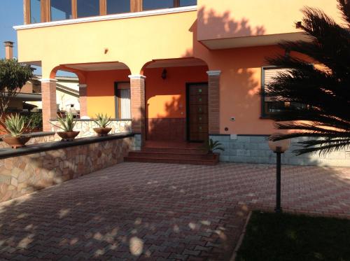 a house with a brick driveway in front of it at Orange Holiday Home in Torvaianica