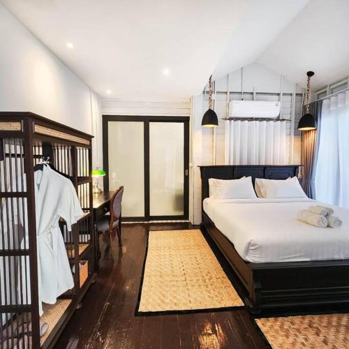 a bedroom with a bed and a desk and a bed and a table at Siraburi boutique pool villa at Center of old town in Chiang Mai