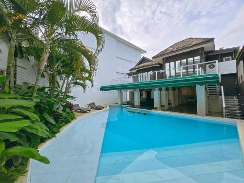 a large swimming pool in front of a house at Siraburi boutique pool villa at Center of old town in Chiang Mai