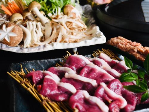 two trays of food on a table with food at Shiroyama Ryokan in Ikuma