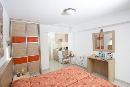 Un dormitorio con una cama y un escritorio y una cocina. en Paul Marie Hotel Apartments, en Ayia Napa