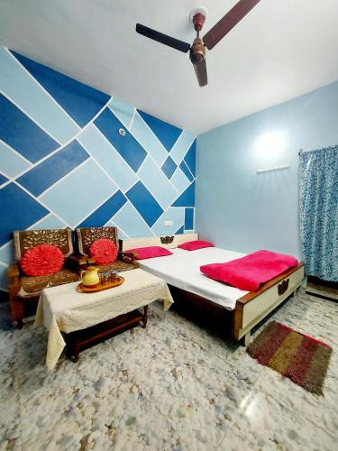 a bedroom with a large bed and a ceiling fan at Mangal kripa homestay in Ujjain