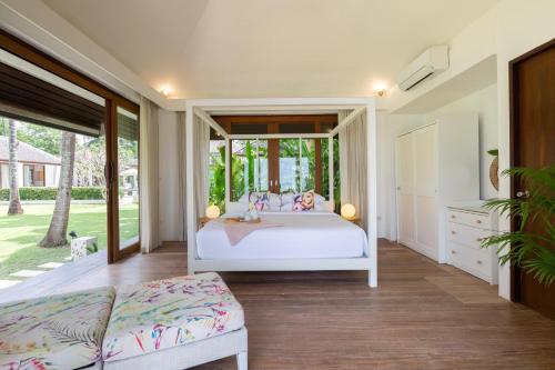 a bedroom with a white bed and a large window at Ban Suriya in Lipa Noi