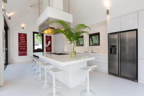 a kitchen with a white island with a potted plant at Ban Suriya in Lipa Noi