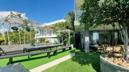 a house with a bench and a table and chairs at Anh Nguyen Oceanfront Luxury Villas Nha Trang in Nha Trang