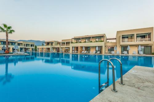 a large swimming pool in front of a hotel at Astir Odysseus Kos Resort and Spa in Tigaki