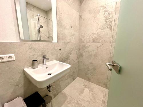a bathroom with a sink and a mirror at Neu wunderschönenes weißes Apartament am Schlössle Zentrum Goldstadt in Pforzheim