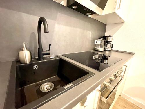 a kitchen with a sink in a kitchen at Neu wunderschönenes weißes Apartament am Schlössle Zentrum Goldstadt in Pforzheim